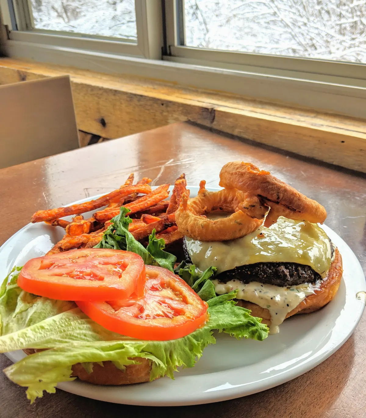 Blackbird burger with onion rings and sweet potato fries